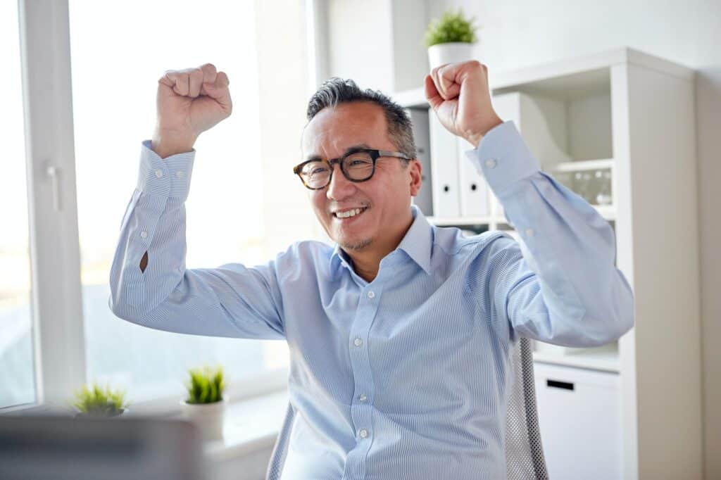 happy businessman celebrating victory at office